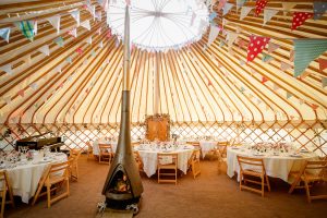 yurt interior with bunting and wood-burning stove