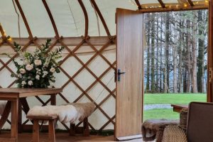 yurt interior with rustic furniture open door in to field
