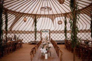 yurt interior with rustic furniture, flowers and wicker lights - Taylor hughes photography